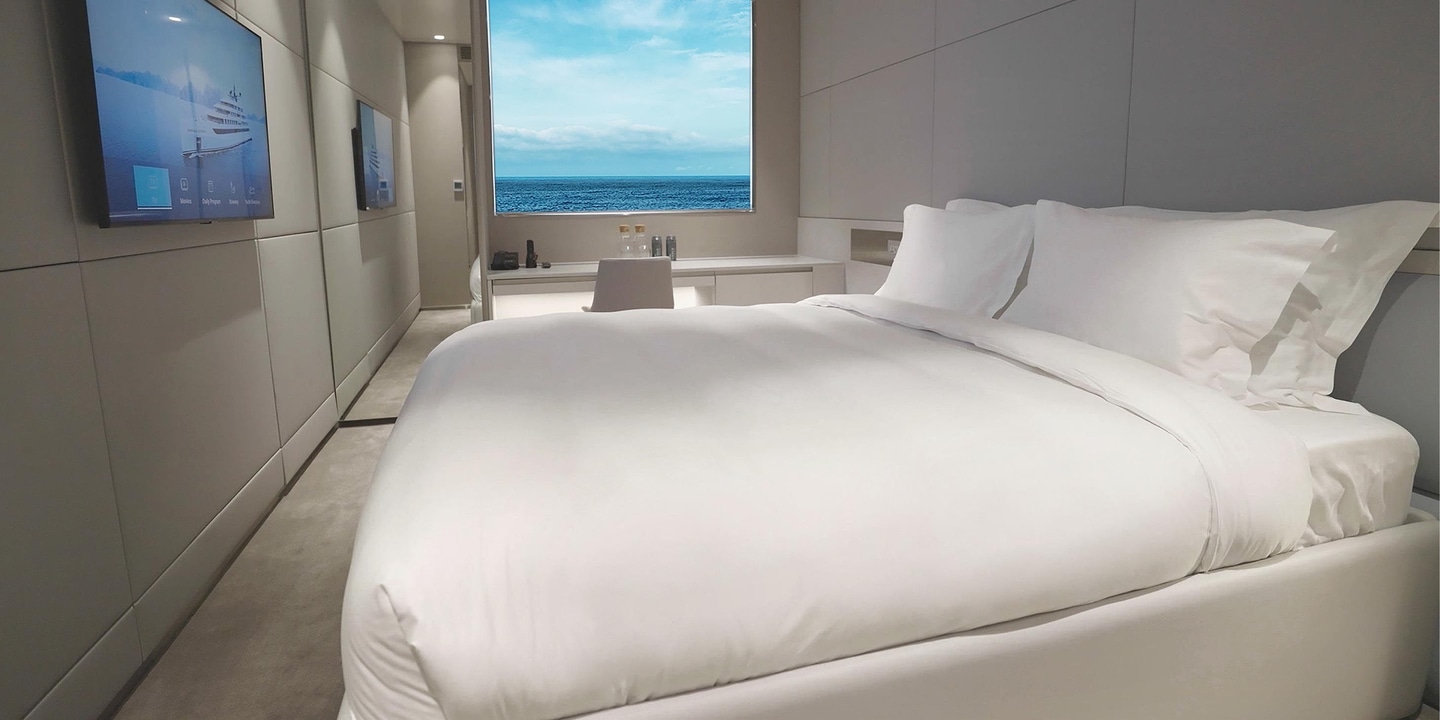 A spacious cabin on board an Emerald Cruises yacht cruise with a large picture window and views out across the ocean