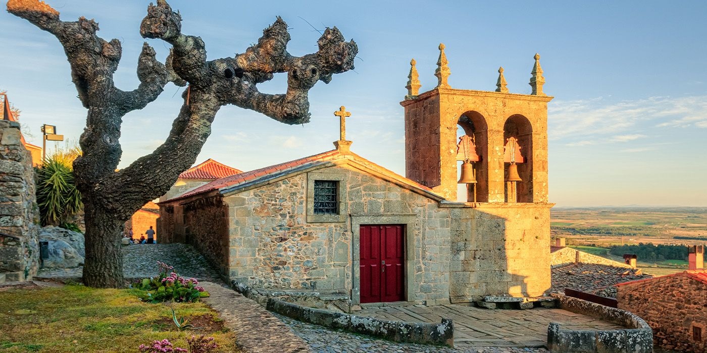 Stone chapel and bell tower in historic Castelo Rodrigo at sunset